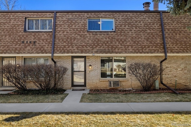 multi unit property with mansard roof, brick siding, and roof with shingles