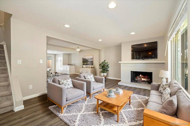 living room with baseboards, stairway, recessed lighting, a fireplace, and wood finished floors