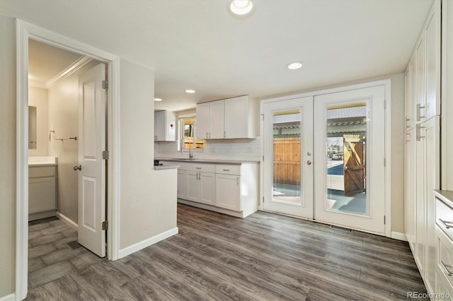 kitchen featuring recessed lighting, decorative backsplash, dark wood-type flooring, white cabinets, and french doors