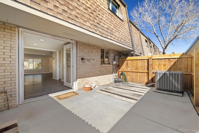 view of patio with cooling unit and fence