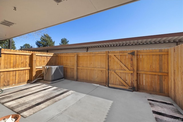 view of patio / terrace featuring cooling unit, fence, and a gate