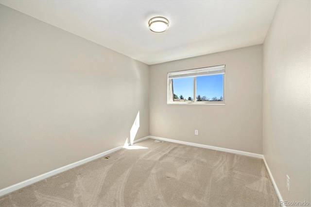 carpeted spare room with baseboards