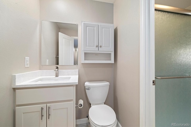 bathroom with a shower stall, vanity, and toilet