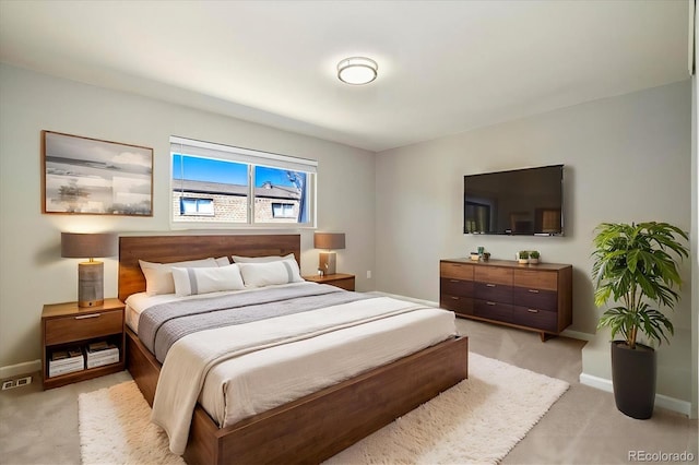 bedroom featuring light colored carpet and baseboards