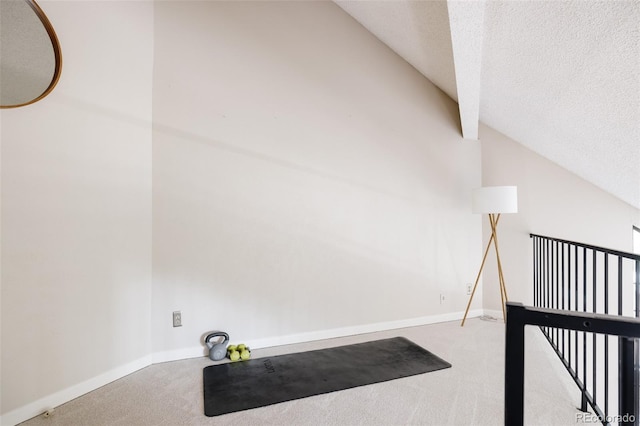 interior space with vaulted ceiling, carpet, and a textured ceiling