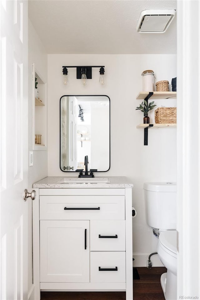 bathroom featuring vanity, hardwood / wood-style floors, and toilet