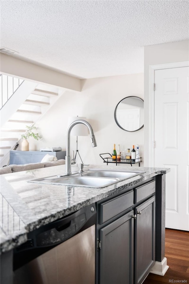 kitchen with light stone countertops, sink, stainless steel dishwasher, and dark hardwood / wood-style flooring