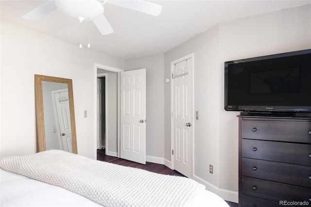 bedroom with ceiling fan, dark hardwood / wood-style flooring, and a textured ceiling