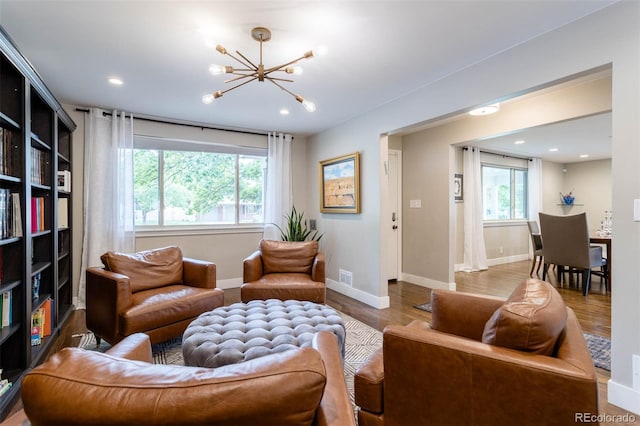 living room with hardwood / wood-style flooring, a wealth of natural light, and a chandelier