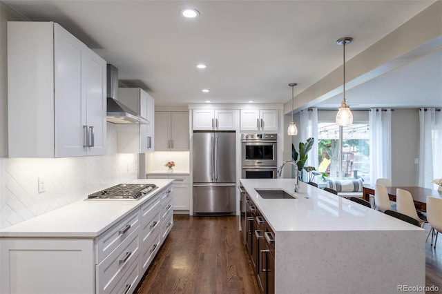 kitchen with dark wood-type flooring, appliances with stainless steel finishes, hanging light fixtures, white cabinets, and decorative backsplash