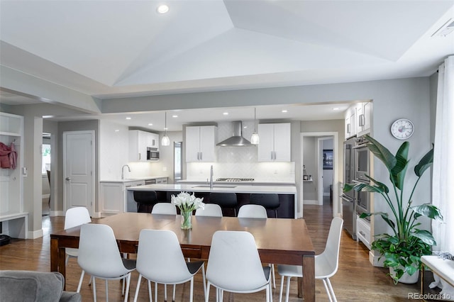 dining room with lofted ceiling, sink, dark wood-type flooring, and plenty of natural light