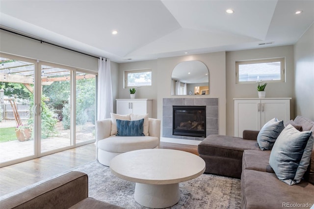 living room with lofted ceiling, a fireplace, and light hardwood / wood-style flooring