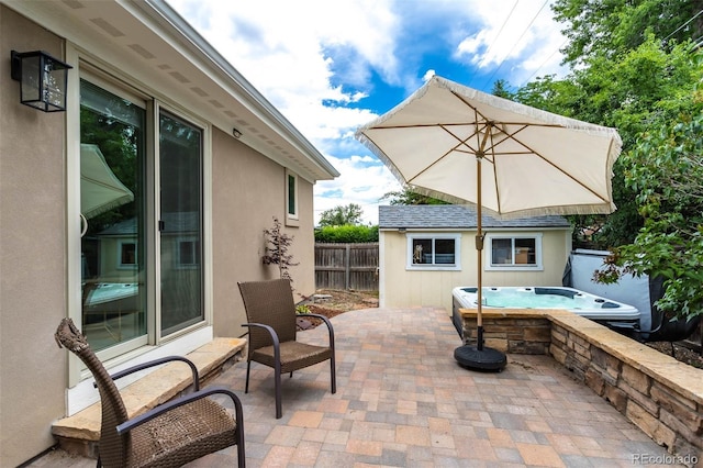 view of patio / terrace featuring an outbuilding and a hot tub