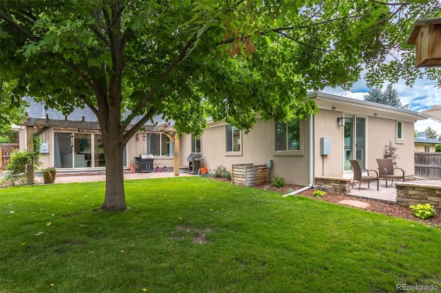 back of property with a lawn and a patio area