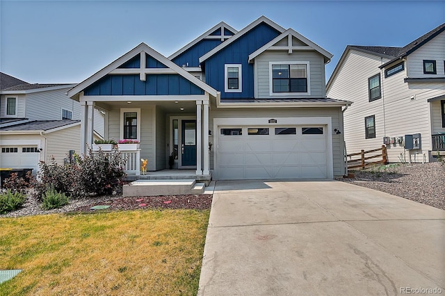 view of front of property with a front yard, covered porch, and a garage