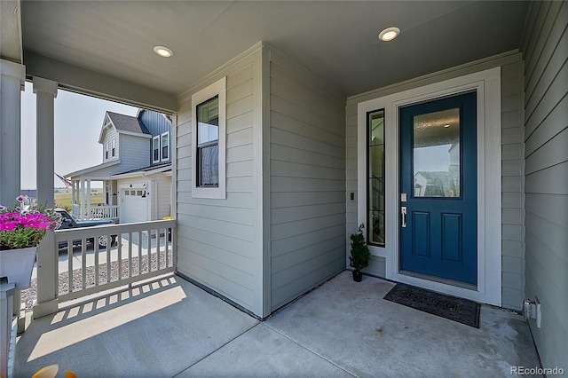 entrance to property featuring a garage and a porch