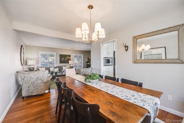 dining area with dark hardwood / wood-style floors and a notable chandelier