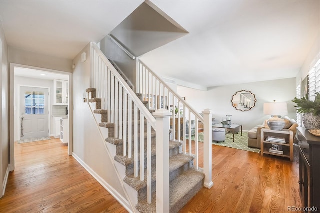 staircase with hardwood / wood-style floors