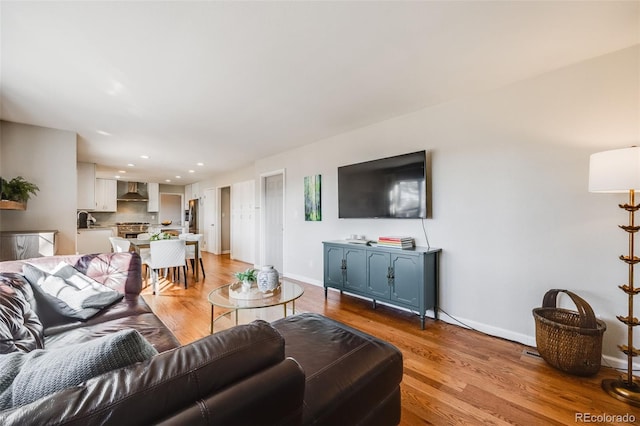 living room with sink and light hardwood / wood-style flooring