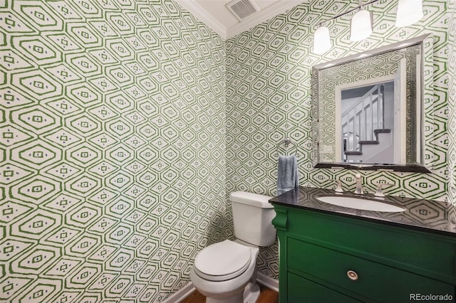 bathroom with crown molding, vanity, and toilet