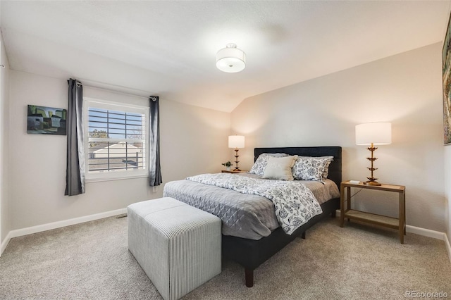 bedroom featuring lofted ceiling and light carpet