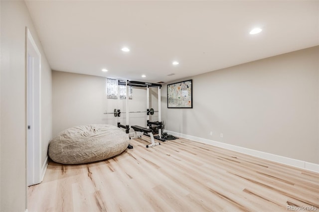 exercise room with light hardwood / wood-style flooring