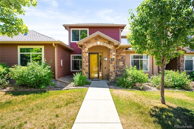 view of front of property with stone siding and a front lawn