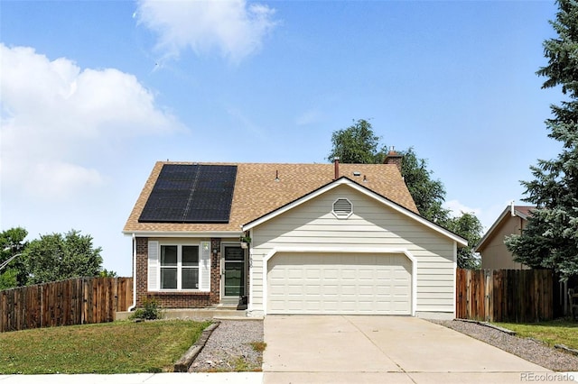 7830 Club Crest Dr, Arvada, CO 80005 - view of front of house featuring concrete driveway, a garage, solar panels, brick siding, and a shingled roof