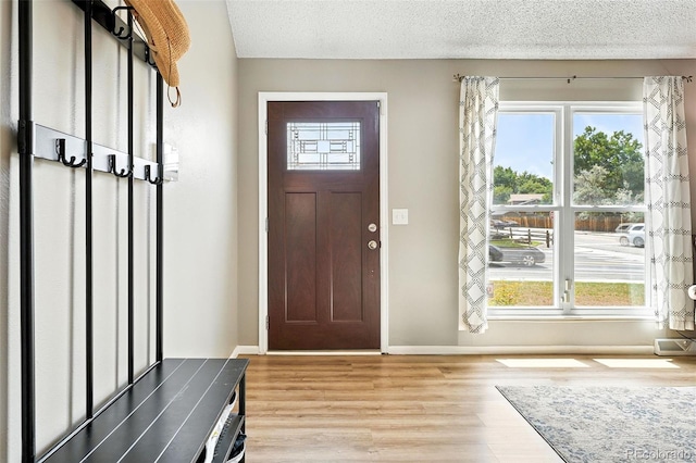 7830 Club Crest Dr, Arvada, CO 80005 - foyer entrance featuring light wood-style flooring and a textured ceiling