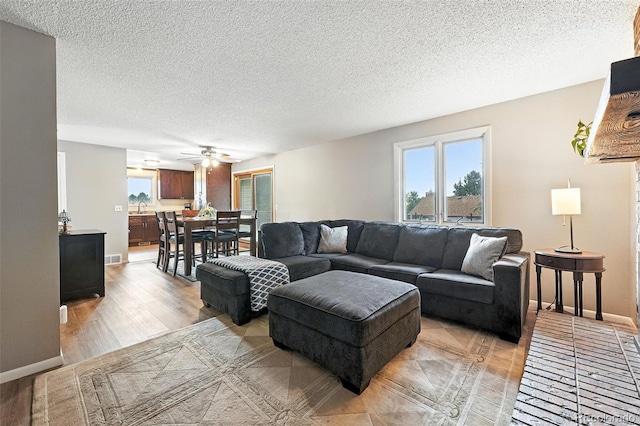 7830 Club Crest Dr, Arvada, CO 80005 - living area featuring a ceiling fan, light wood-type flooring, and a textured ceiling