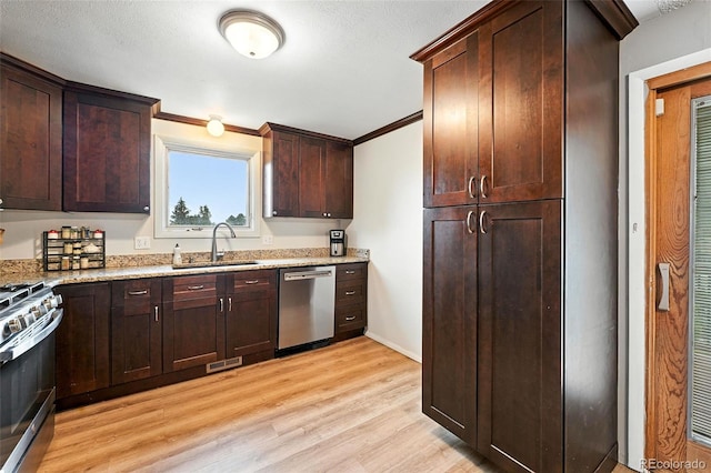 7830 Club Crest Dr, Arvada, CO 80005 - kitchen with appliances with stainless steel finishes, light wood-type flooring, light stone countertops, ornamental molding, and dark brown cabinets