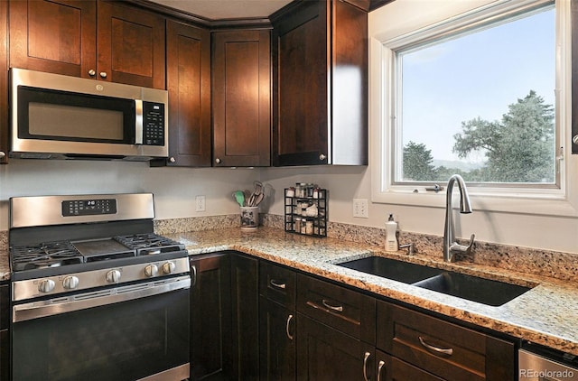 7830 Club Crest Dr, Arvada, CO 80005 - kitchen with appliances with stainless steel finishes, dark brown cabinetry, and light stone countertops