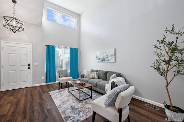 living area with visible vents, baseboards, and wood finished floors