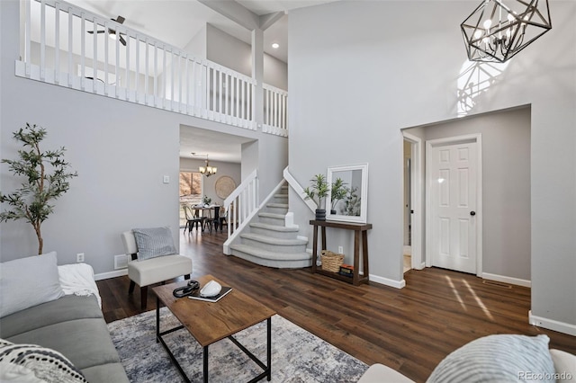 living area featuring stairs, wood finished floors, baseboards, and an inviting chandelier