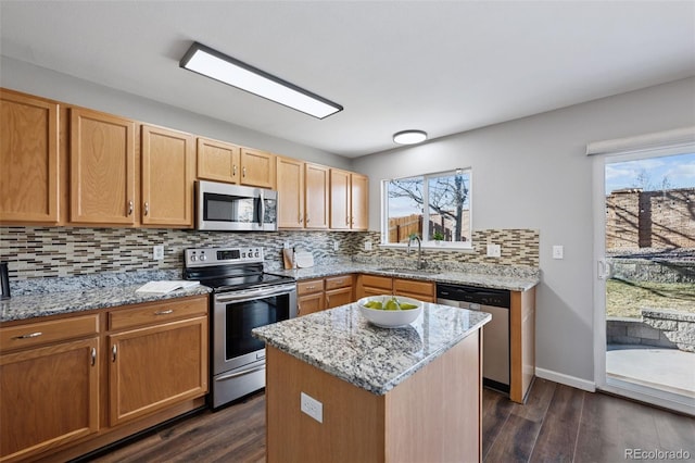 kitchen featuring appliances with stainless steel finishes, backsplash, a sink, and dark wood finished floors