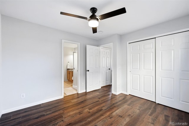 unfurnished bedroom featuring a closet, ensuite bathroom, dark wood-type flooring, ceiling fan, and baseboards