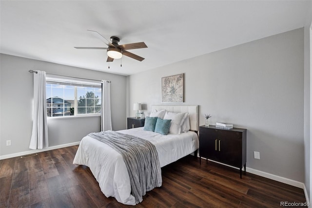 bedroom with a ceiling fan, wood finished floors, visible vents, and baseboards