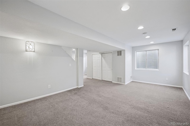 below grade area featuring carpet floors, recessed lighting, visible vents, and baseboards