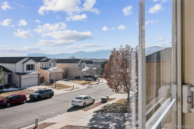 exterior space with sidewalks, a residential view, a mountain view, and curbs