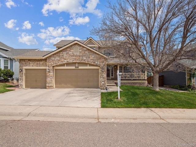 view of front of house with an attached garage, stone siding, a porch, a front yard, and driveway