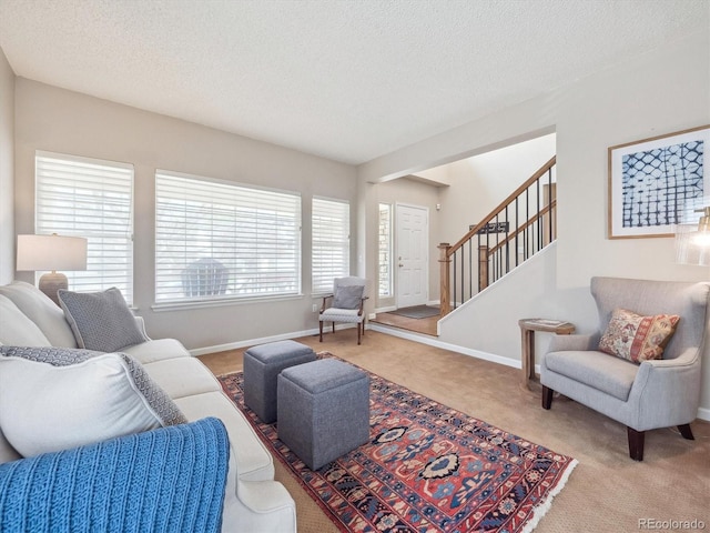 living room with stairway, baseboards, carpet, and a textured ceiling