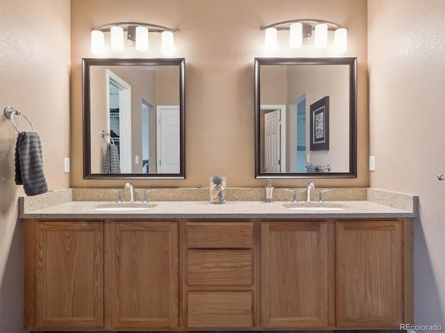 full bathroom with double vanity and a sink