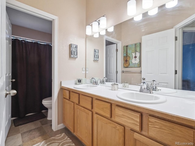 full bathroom with a sink, toilet, and double vanity