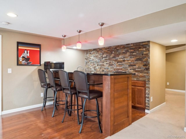 bar featuring bar, baseboards, recessed lighting, and decorative light fixtures