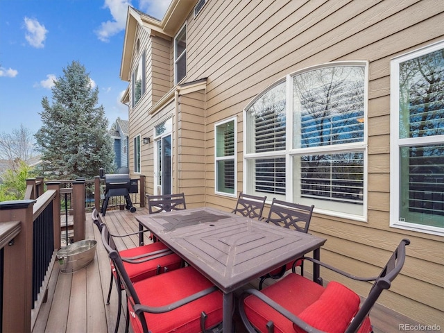 deck with outdoor dining space and a grill