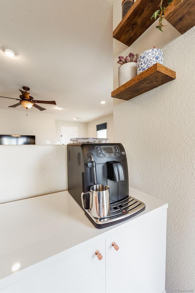 kitchen featuring ceiling fan and white cabinets