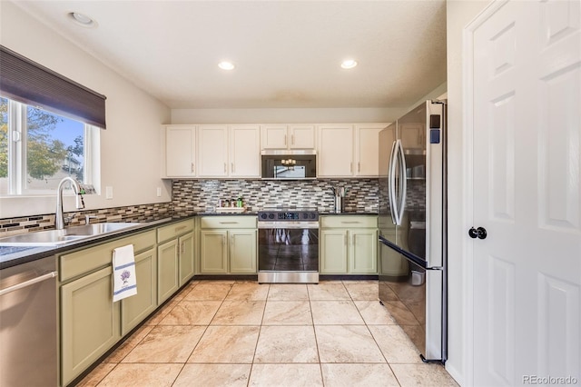 kitchen featuring sink, light tile patterned floors, appliances with stainless steel finishes, tasteful backsplash, and green cabinetry