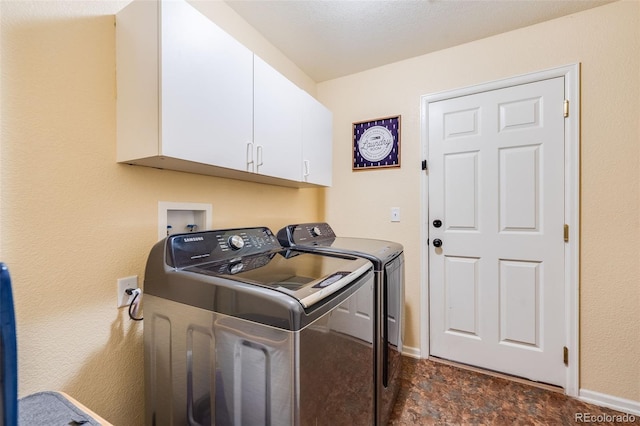 clothes washing area with cabinets and washing machine and dryer