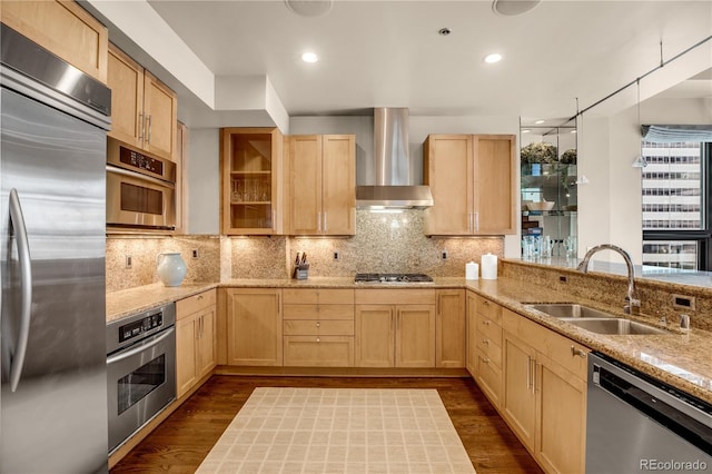 kitchen with light brown cabinetry, sink, dark hardwood / wood-style flooring, stainless steel appliances, and wall chimney range hood