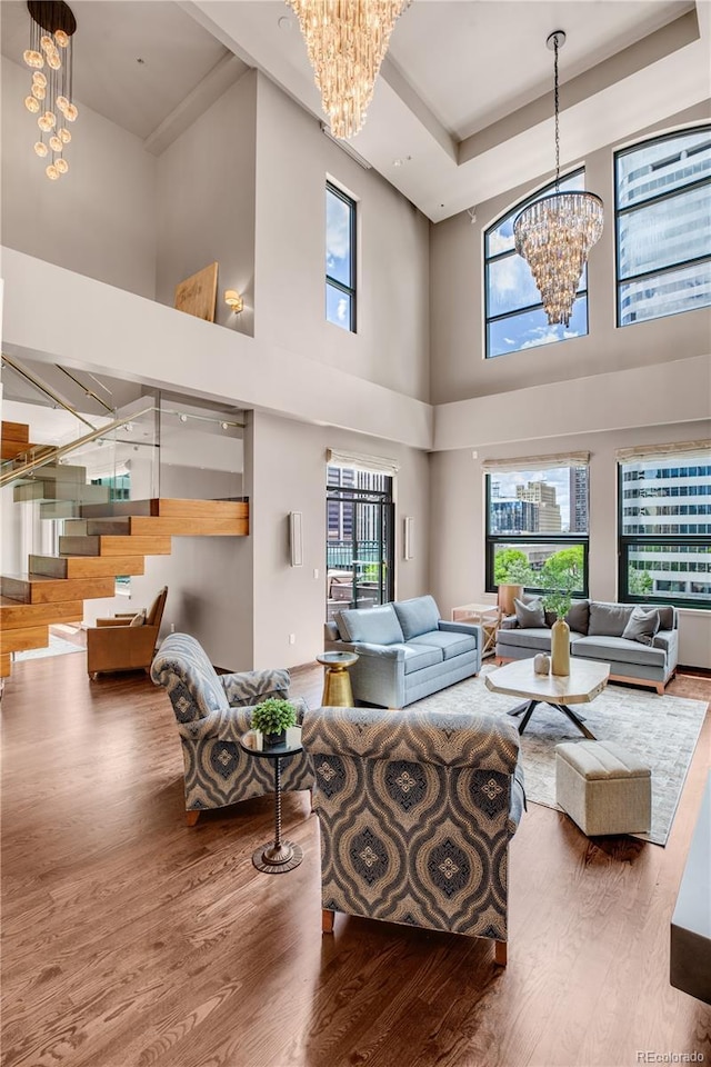 living room with an inviting chandelier, a wealth of natural light, and wood-type flooring